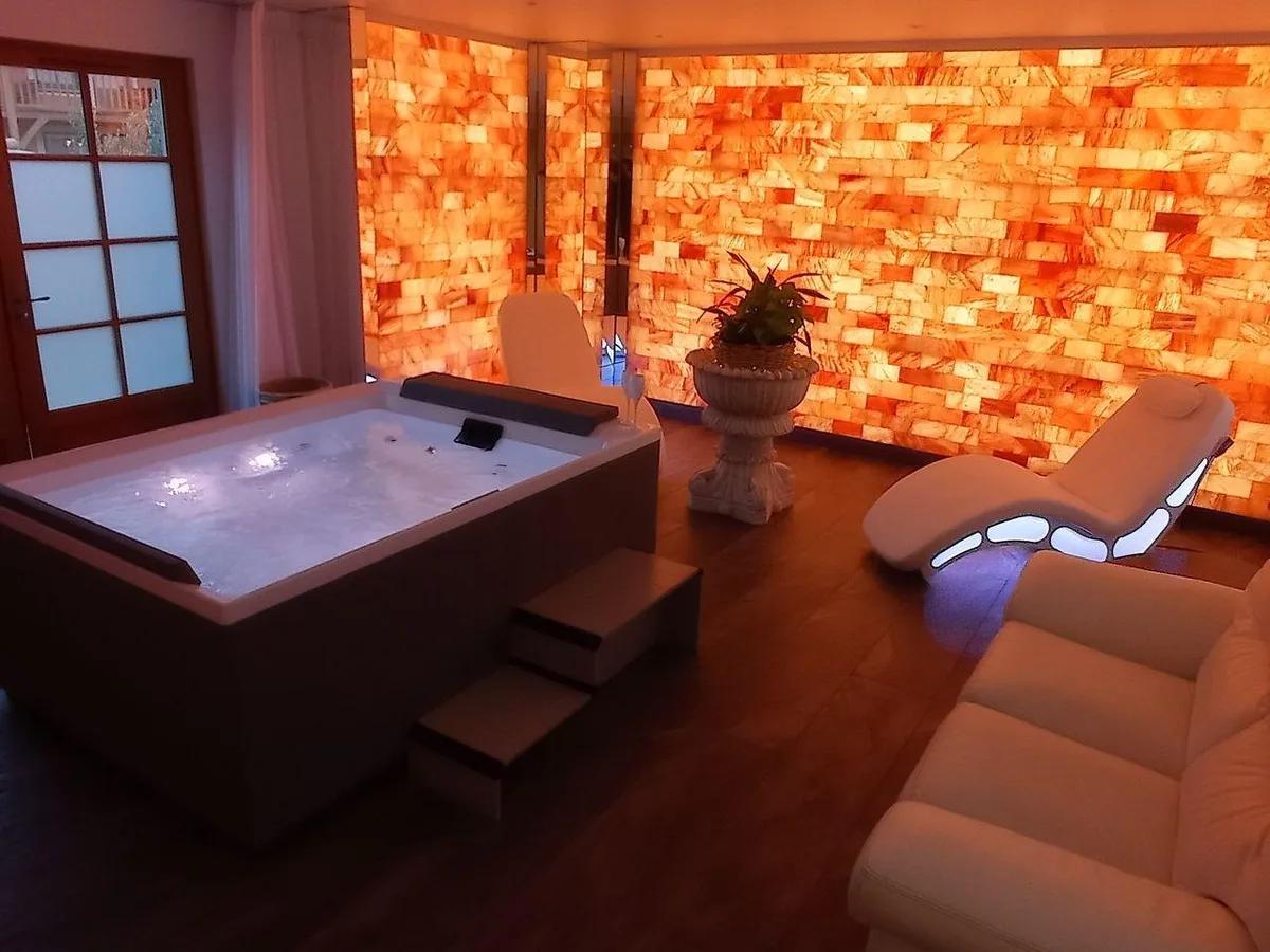 Luxury private spa with a hot tub and illuminated Himalayan salt walls